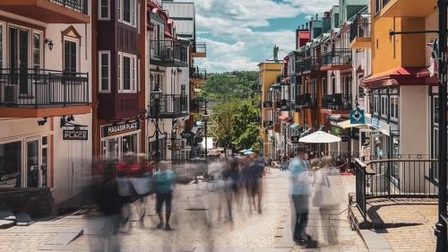a group of people walking down a city street at Townhouse With Free Shuttle To Tremblant Resort in Mont-Tremblant