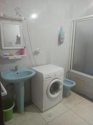 a bathroom with a washing machine and a sink at Quartier Anne Marie in Temara
