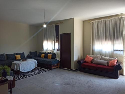 a living room with two couches and a table at Quartier Anne Marie in Temara