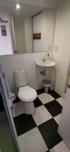 a bathroom with a toilet and a sink at Parrot House San Antonio in Cali