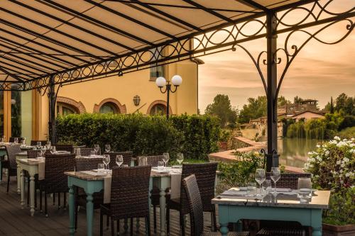 a restaurant with tables and chairs and a view of a river at Hotel Mulino di Firenze - WorldHotels Crafted in Florence