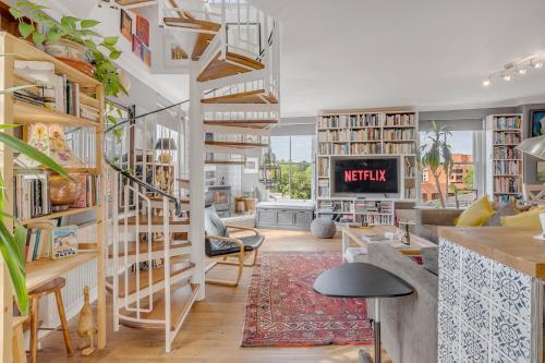 a living room with a spiral staircase in a loft at Luxe Penthouse with Rooftop Garden & Views in Norwich