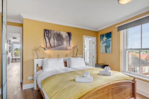 a bedroom with a large bed with two towels on it at Luxe Penthouse with Rooftop Garden & Views in Norwich