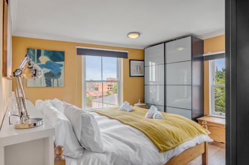 a bedroom with a large bed with yellow walls at Luxe Penthouse with Rooftop Garden & Views in Norwich