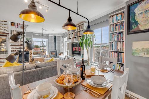 a dining room with a table and chairs and a couch at Luxe Penthouse with Rooftop Garden & Views in Norwich
