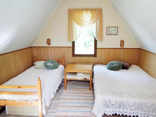 a attic room with two beds and a window at Holiday home LULEÅ in Luleå