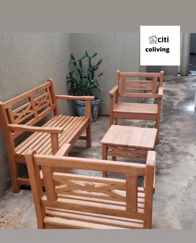 deux bancs en bois, une table et une plante dans l'établissement CITI COLIVING HOSTEL, à Campo Grande
