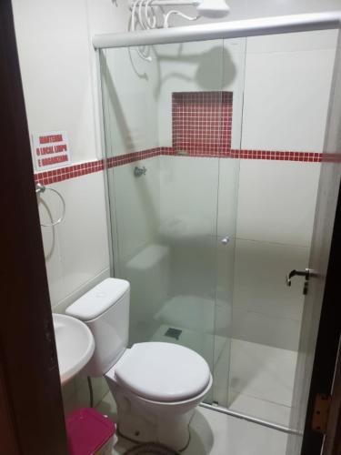 uma casa de banho com um WC e uma cabina de duche em vidro. em CITI COLIVING HOSTEL em Campo Grande