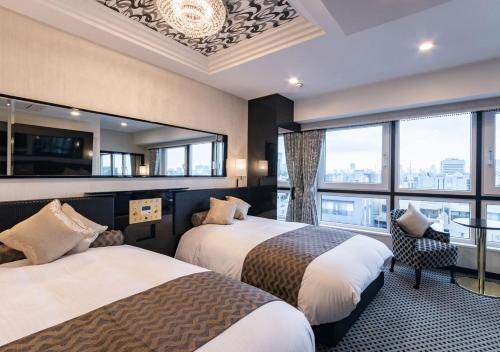 a hotel room with two beds and a large window at APA Hotel Asakusa Shin Okachimachi Ekimae in Tokyo