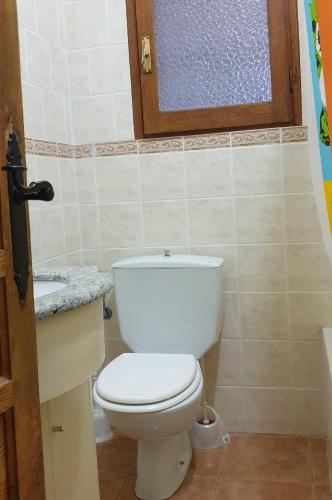 a bathroom with a white toilet and a window at Casa con Encanto Mitos in Pelayos del Arroyo
