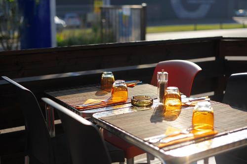 a table with chairs and bottles of beer on it at FH Confort Hotel Orléans Co'met in Orléans