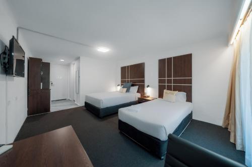 a hotel room with two beds and a couch at The Select Inn Gosford in Gosford