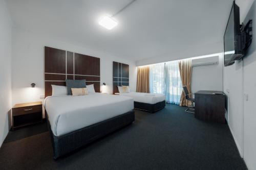 戈斯福德The Select Inn Gosford的有两张床和一张书桌的酒店房间
