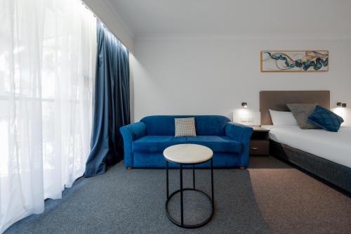 a room with a couch and a chair and a bed at The Select Inn Gosford in Gosford