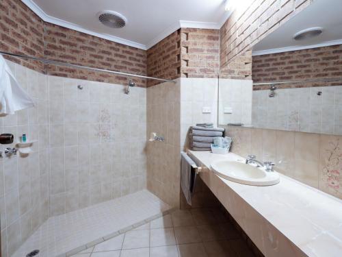 ein Bad mit einem Waschbecken und einer Dusche in der Unterkunft Eildon Parkview Motor Inn Room 12 in Eildon
