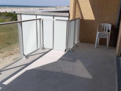 une chaise assise sur une terrasse avec vue sur la plage dans l'établissement Appart 2 ch. avec accès plage et parking privé - FR-1-674-34, à Berck-sur-Mer