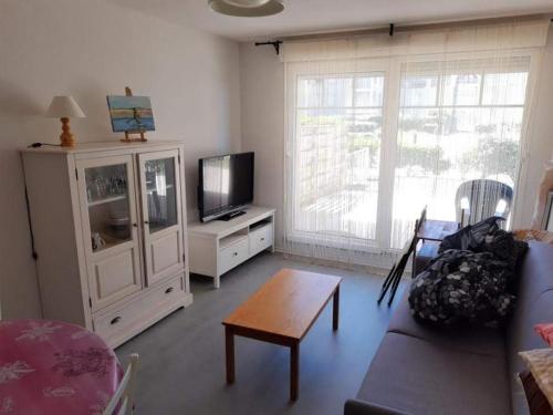 Televízia a/alebo spoločenská miestnosť v ubytovaní Appartement RDC avec Terrasse, Jardin et Accès Plage - Capacité 4 Pers, Animaux et Fumeurs Non Admis - FR-1-674-4