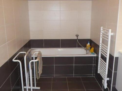 La salle de bains est pourvue d'une baignoire et de carrelage noir et blanc. dans l'établissement Appartement RDC avec Terrasse, 2 Chambres, Parking Privé et Animaux Admis - Berck - FR-1-674-32, à Berck-sur-Mer