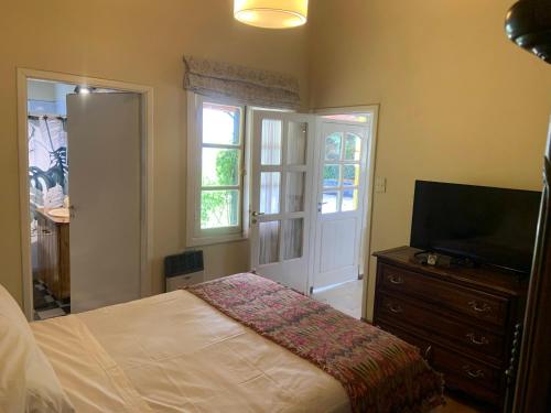 a bedroom with a bed and a flat screen tv at Las Rucas in San Martín de los Andes