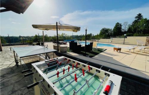 a ping pong table in front of a swimming pool at Amazing Home In Montegrosso Cinaglio in Monale