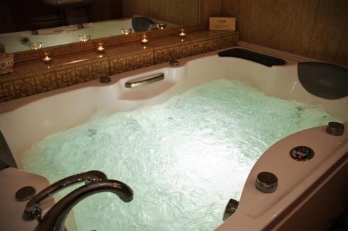 a bath tub filled with water in a bathroom at Hotel Aleksander in Włocławek