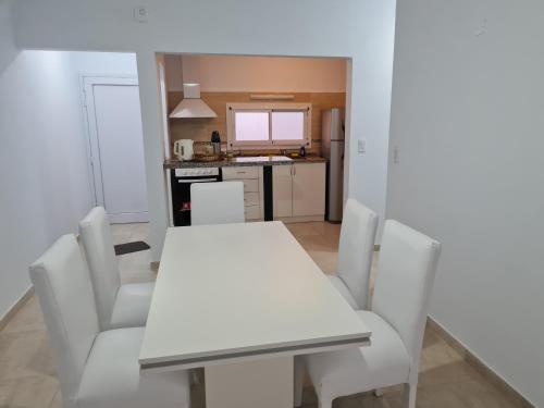 uma sala de jantar com uma mesa branca e cadeiras em Del Sur Alquiler temporario em Sunchales