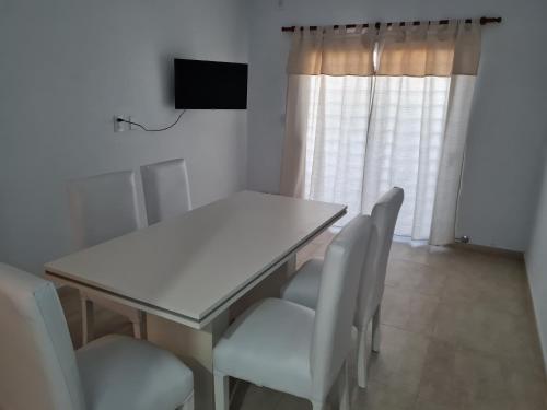 uma sala de jantar com uma mesa branca e cadeiras em Del Sur Alquiler temporario em Sunchales