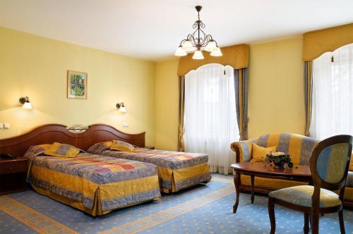 a hotel room with two beds and a table at Hotel Aleksander in Włocławek