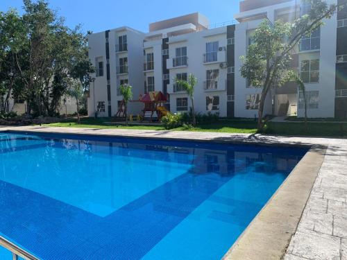 a large blue swimming pool in front of a building at Departamento 2 habitaciones vista a la alberca Sky by EITA in Cancún