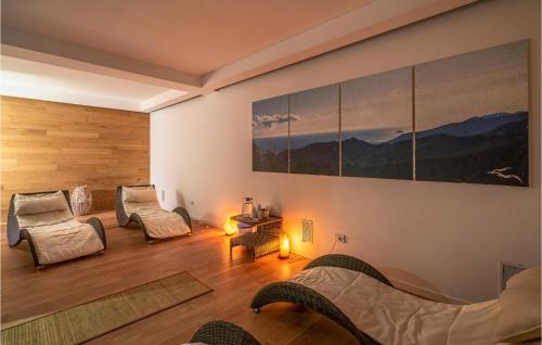 a living room with two chairs and a painting on the wall at Amazing Home In Magliolo With Sauna in Magliolo