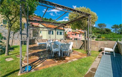 a patio with a table and chairs in a yard at Amazing Home In Magliolo With Sauna in Magliolo