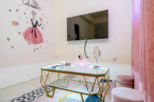 a living room with a glass table and a tv at 3Kiss Homestay in Wujie