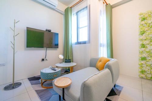 a living room with a couch and a tv at 3Kiss Homestay in Wujie