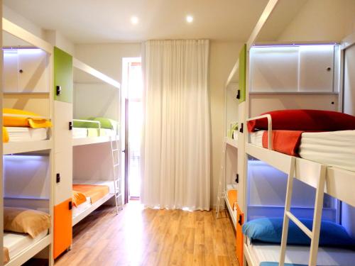 a room with multiple bunk beds with wooden floors at Urban Youth Hostel in Valencia