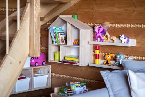 a room with a bunk bed with shelves and toys at Domek drewniany w górach Jacuzzi & Balia - Osada Chełm in Stróża