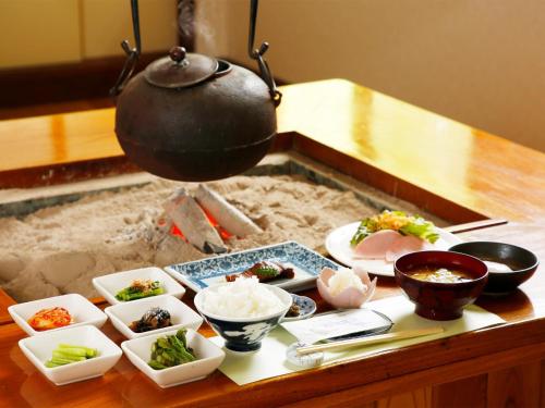 a table with dishes of food and a pot on it at Oyado Fubuki - Vacation STAY 45506v in Nozawa Onsen