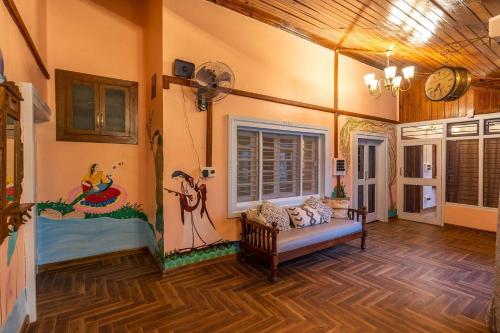 Una sala de estar con un cuadro en la pared. en StayVista at Vintage Musings 3BR in Dharamshala with vintage charm, en Dharamshala
