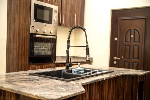 uma cozinha com um lavatório e um micro-ondas em Prince's - Villa - Minimum of 3 nights booking em Akure