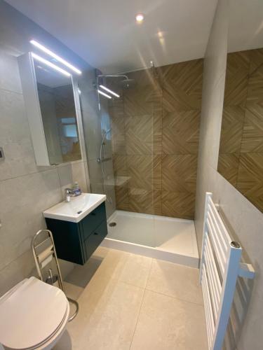 y baño con ducha, aseo y lavamanos. en Brand New Top Floor Apartment at Mokotow en Varsovia