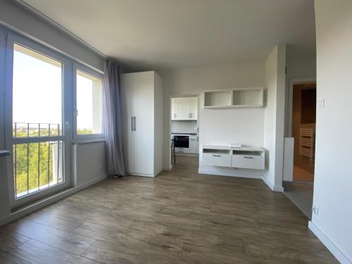 Habitación vacía con cocina y ventana grande. en Brand New Top Floor Apartment at Mokotow en Varsovia