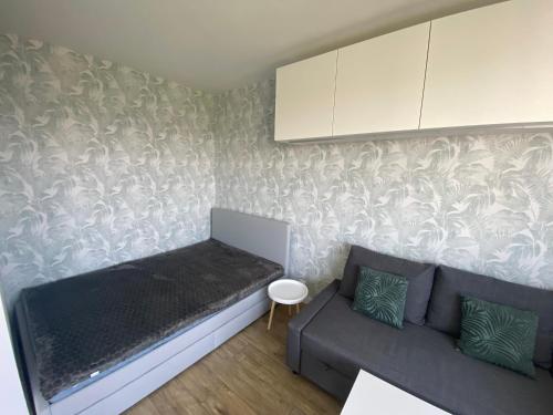 mały salon z kanapą i szafką w obiekcie Brand New Top Floor Apartment at Mokotow w Warszawie