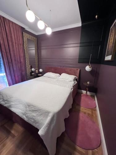 a bedroom with a large bed with purple walls at Apartment Przno in Sveti Stefan