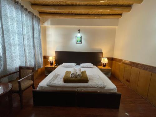 a bedroom with a bed with two towels on it at New Royal Guest House in Leh