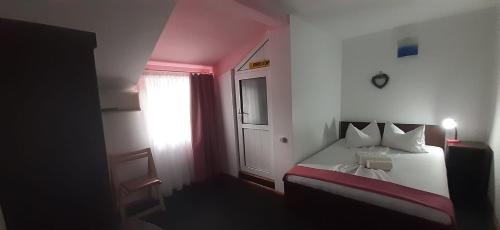 a bedroom with a bed with a clock on the wall at Casa David in Sulina