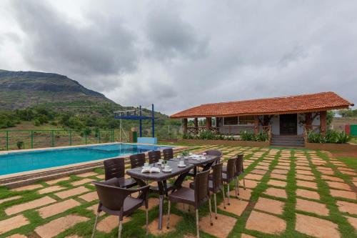 Πισίνα στο ή κοντά στο StayVista's Ficus Farms - Mountain-View Haven with Rustic Artsy Interiors, Outdoor Pool, Glasshouse, Home Theatre & Karaoke Delight