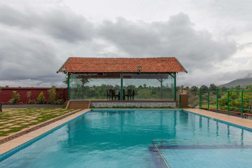 Πισίνα στο ή κοντά στο StayVista's Ficus Farms - Mountain-View Haven with Rustic Artsy Interiors, Outdoor Pool, Glasshouse, Home Theatre & Karaoke Delight