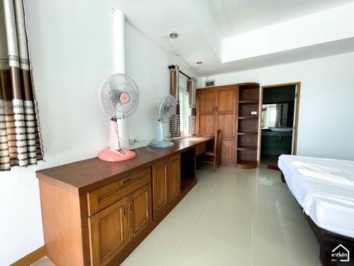 a bedroom with a desk with a fan on it at Bottle Beach 2 Bungalows in Bottle Beach