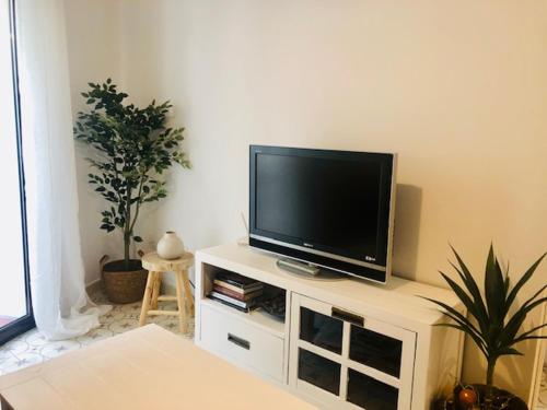 a flat screen tv sitting on top of a white entertainment center at Precioso piso en el centro neurálgico de Olot in Olot