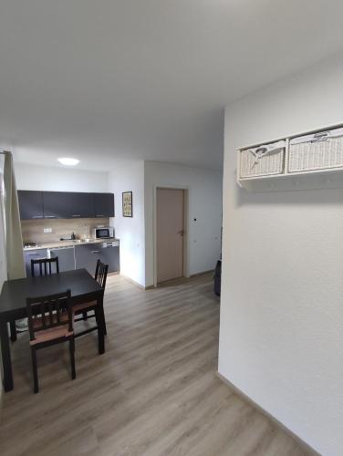 Ferienwohnung Steigner في Dierbach: غرفة معيشة مع طاولة وكراسي ومطبخ