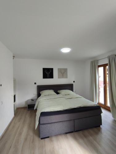 una camera da letto con un grande letto e pareti bianche di Ferienwohnung Steigner a Dierbach